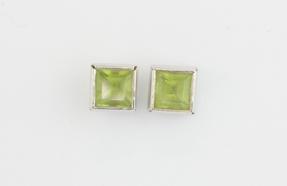 A similar pair of hallmarked 9ct white gold peridot set stud earrings, L. 5mm.