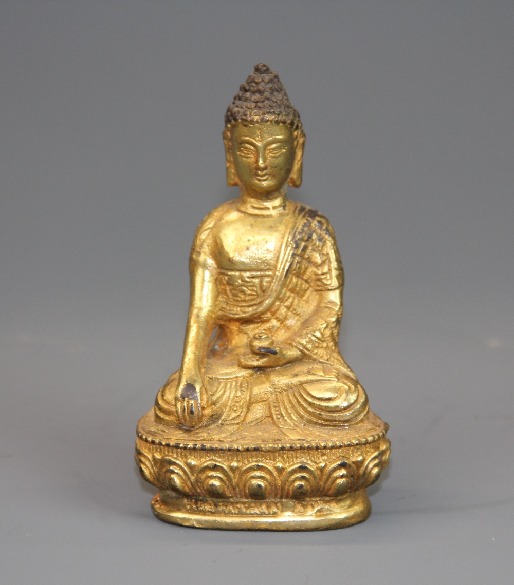 A small Sino-Tibetan gilt bronze figure of a seated Buddha, H. 10.5cm.