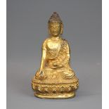 A small Sino-Tibetan gilt bronze figure of a seated Buddha, H. 10.5cm.