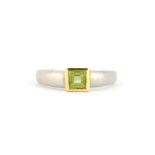 A hallmarked 18ct white and yellow gold ring set with a princess cut peridot, (N).