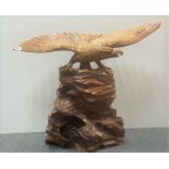 A large carved wooden figure of an eagle on a rock, H. 60cm. Wing span 78cm.