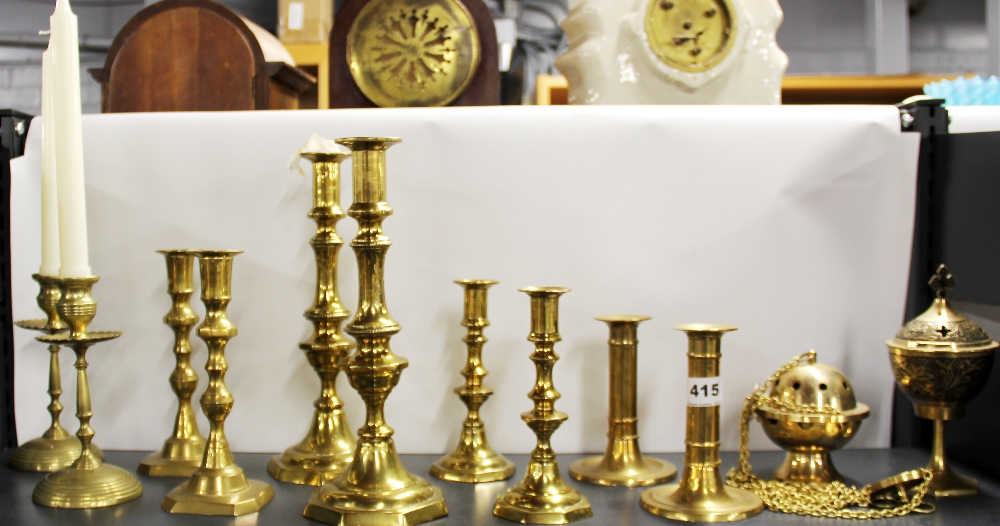 Five pairs of brass candlesticks and two other items.