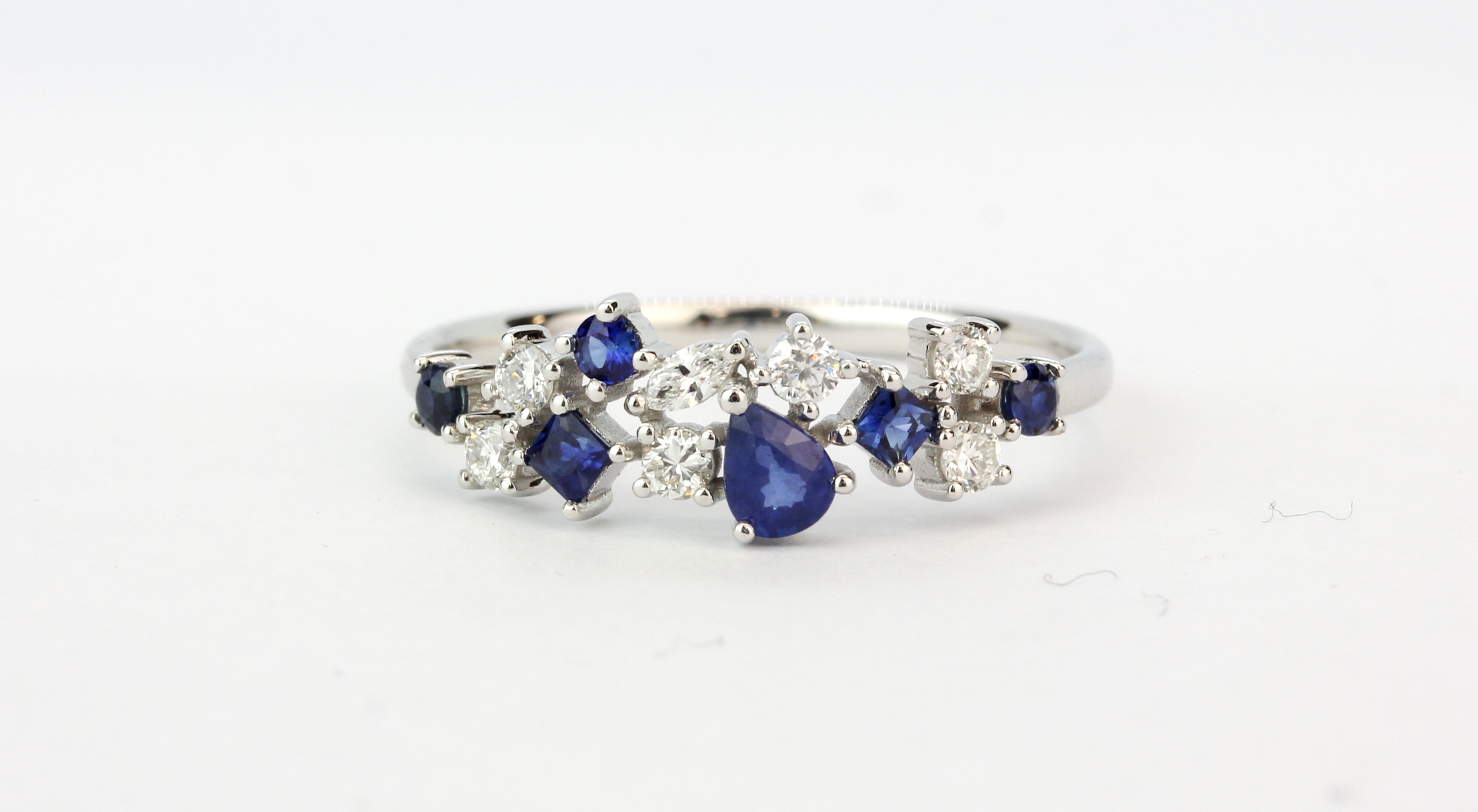 An 18ct white gold ring set with mixed cut sapphires and diamonds, (P.5).