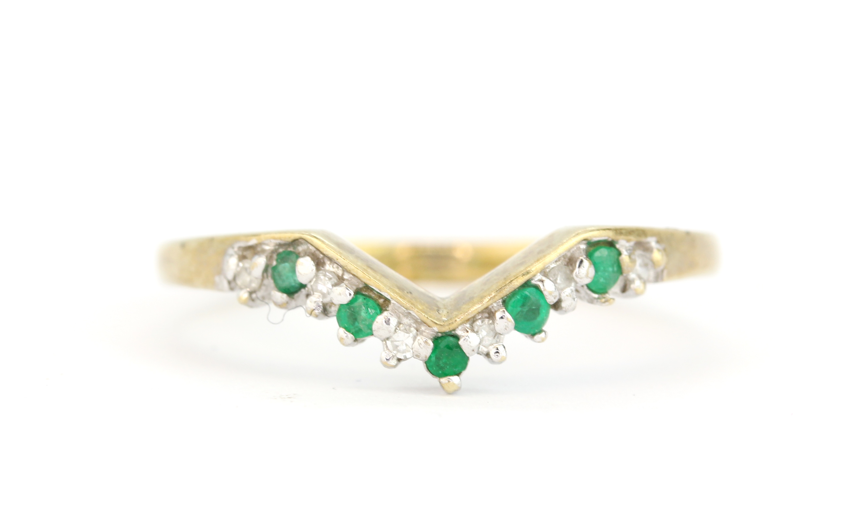 A hallmarked 9ct yellow gold wishbone ring set with round cut emeralds and diamonds, (Q.5).