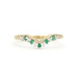 A hallmarked 9ct yellow gold wishbone ring set with round cut emeralds and diamonds, (Q.5).