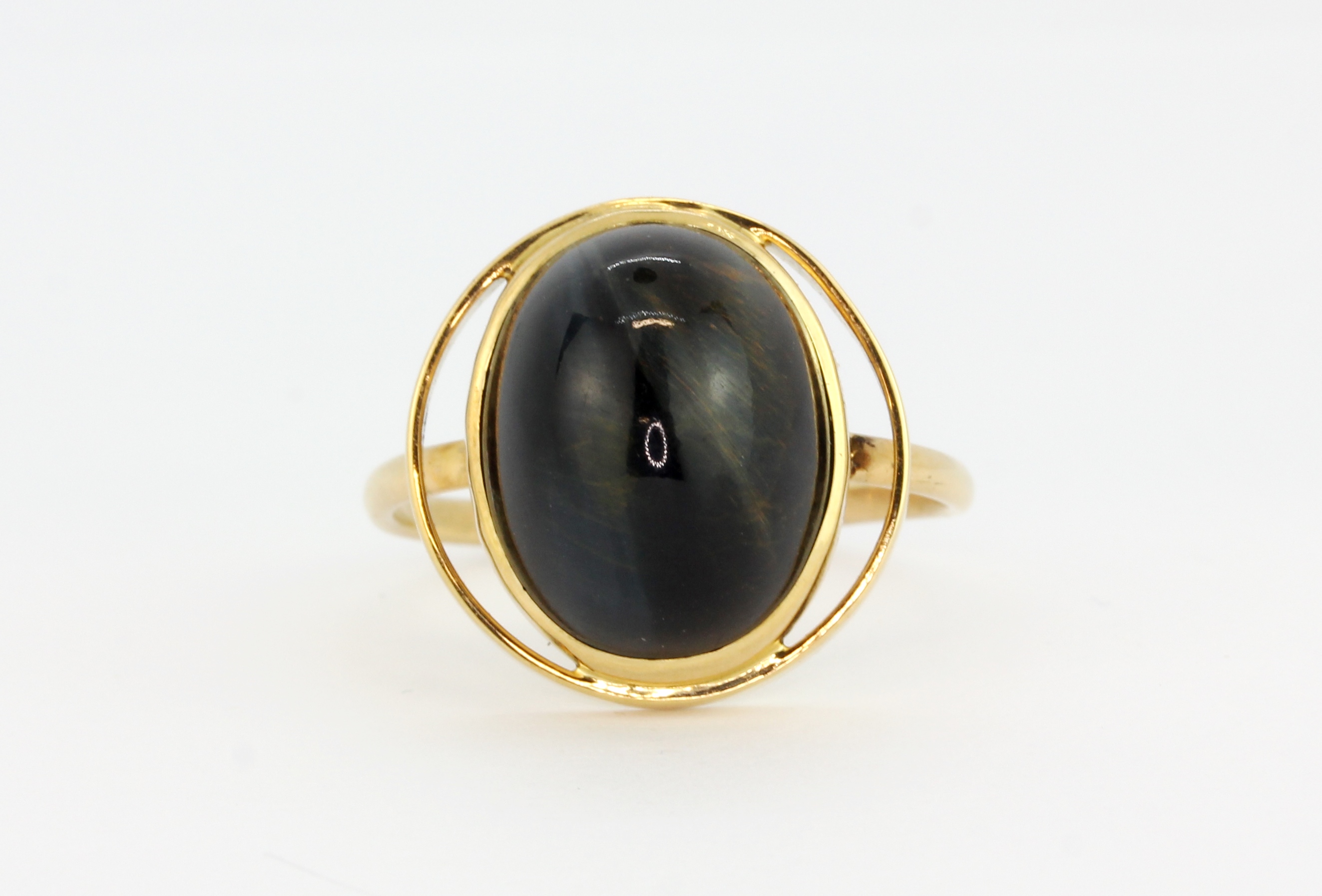 A 14ct yellow gold (stamped 14k) ring set with a cabochon cut black tiger's eye, (P).