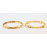 Two hallmarked 22ct yellow and white gold bangles, Dia. 7.2cm.