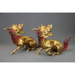 A superb pair of Sino-Tibetan gilt and painted bronze dragon figures, L. 41cm. H. 24cm.