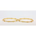 Two hallmarked 22ct yellow and white gold bangles, Dia. 7.2cm.