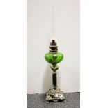 A 19th century oil lamp with green glass well, H. 61cm.