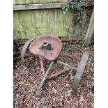 A vintage rotovator seat on wheels.