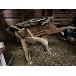 A large vintage wooden wheel barrow.