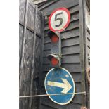 A Forrest City Manchester traffic light and two direction signs.