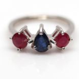 A 925 silver ring set with a pear cut sapphire flanked by rubies, (O).