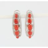 A pair 925 silver earrings set with cabochon cut coral surrounded by white stones, L. 2.5cm.