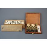 A cased travelling chess set with a bone and ebony draughts set.