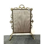 An ornate brass fire screen.