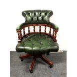 A leather upholstered captain's style swivel desk chair.