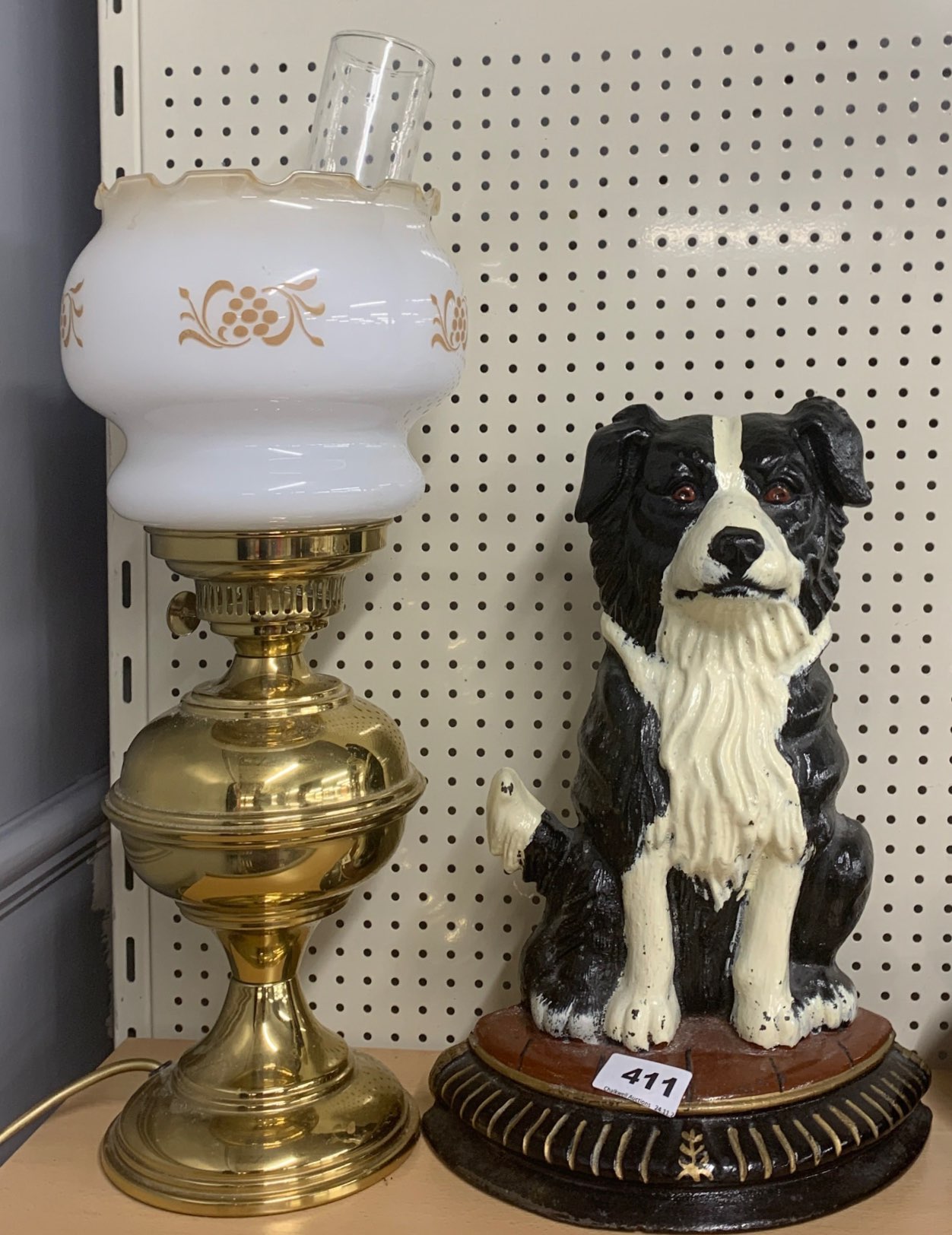 A painted cast iron door stop and an oil lamp style table lamp.