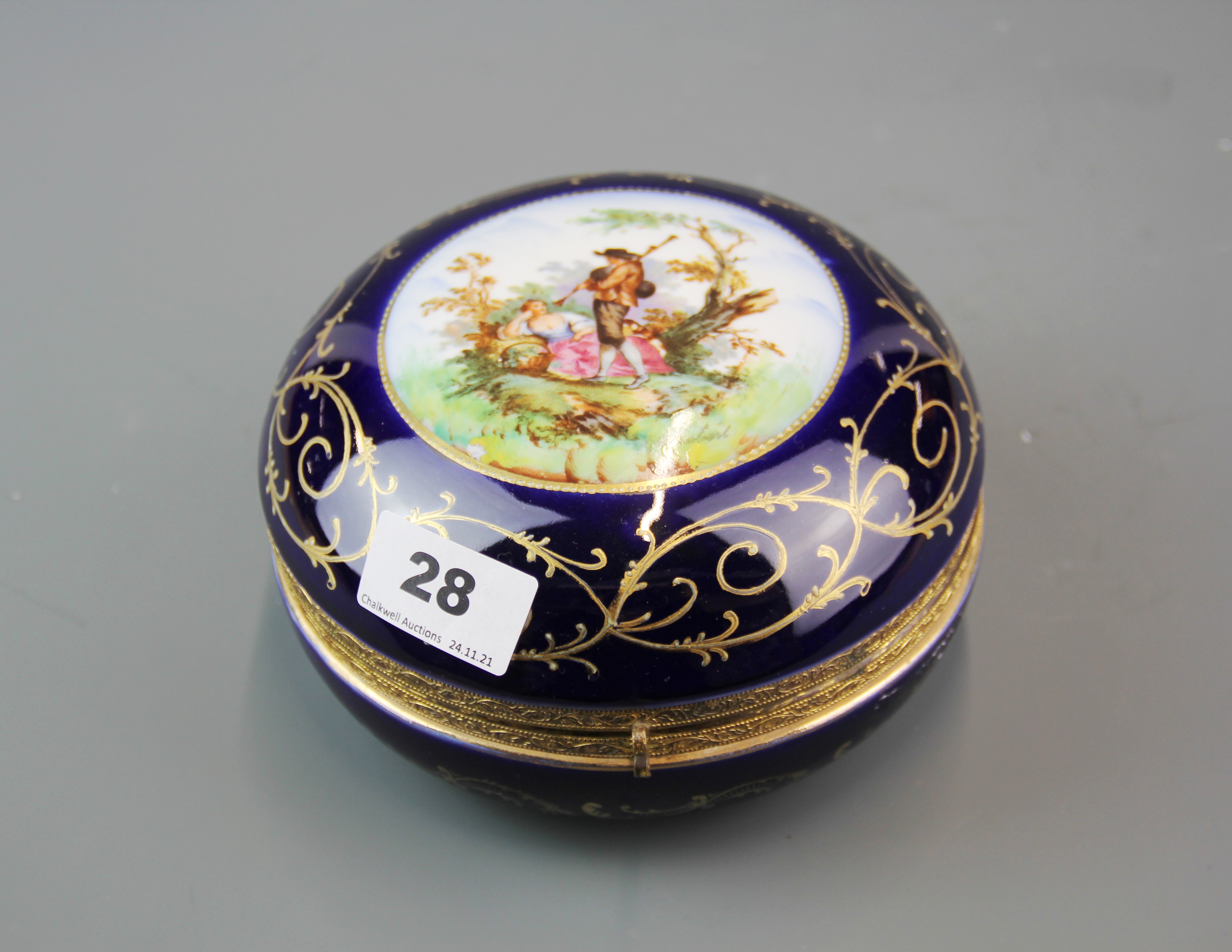 A 19th century gilt mounted and hand painted porcelain box, Dia. 16cm.