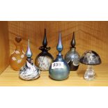 A group of five glass perfume bottles and a mushroom paperweight.