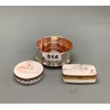 Two French royale porcelain boxes, W. 6.5cm, together with a hallmarked silver wine bottle coaster.