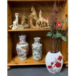 A group of three ceramic vases and a group of figures.