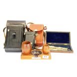 A smoker's stand with bakelite ashtray made from the teak of HMS Ajax, together with two cameras and
