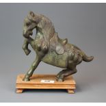 A heavy patinated Chinese bronze figure of a horse on a carved wooden base, overall H. 24cm.