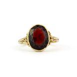 An antique Oriental yellow metal (stamped 333) ring set with a large oval cut garnet, (O.5).