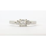 A platinum (stamped 950) ring set with a princess cut diamond and two brilliant cut diamonds, centre