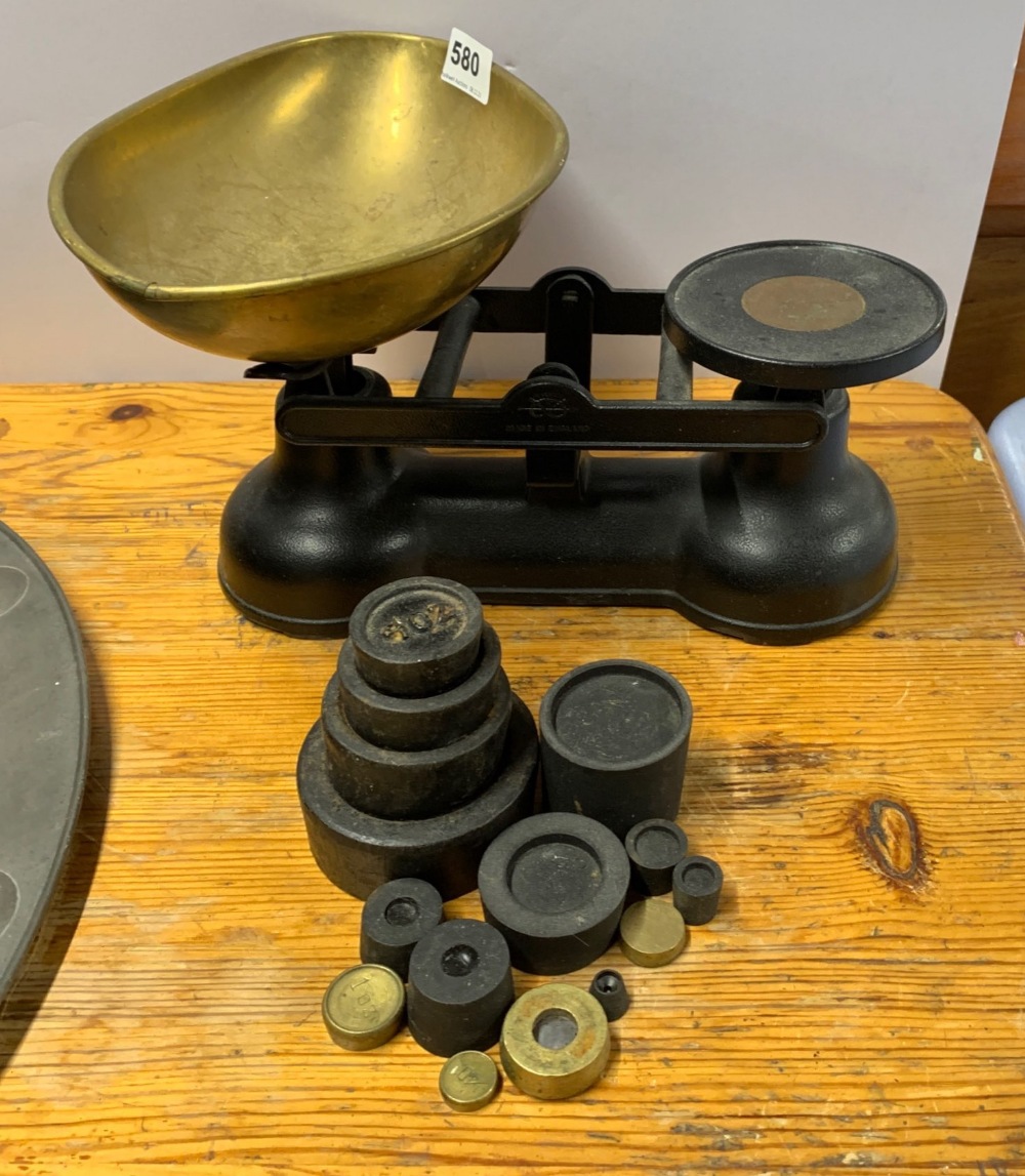 A brass and cast iron kitchen scale and weights.