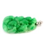 A large carved jade pendant on a white metal (tested 18ct gold) bail set with brilliant and baguette