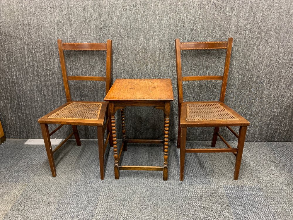 A pair of Edwardian cane seated bedroom chairs and a small oak side table.