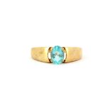A hallmarked 9ct yellow gold ring set with a blue stone, (U). Approx. 3.3gr.