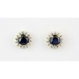 A pair of 9ct yellow gold (stamped 9k) stud earrings set with heart shaped sapphires surrounded by