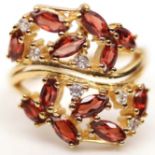 A 925 silver gilt ring set with spessartine garnets and white stones, (S).