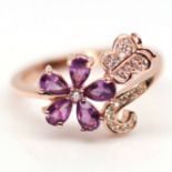 A 925 silver rose gold gilt ring set with pear cut amethysts and white stones, (S).