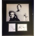 Simon and Garfunkel signature pieces mounted below black and white photo. Approx overall size 20x22.