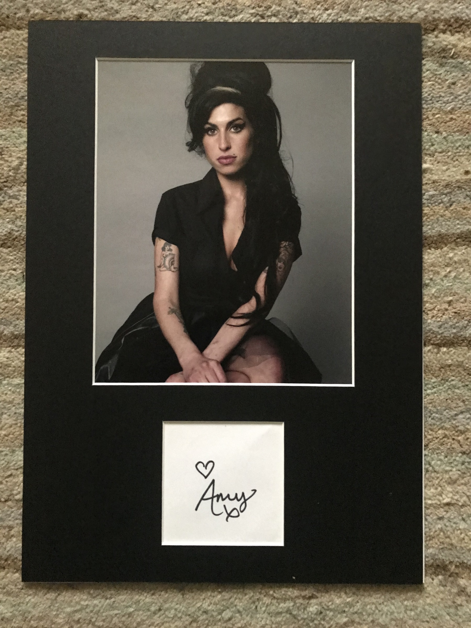 Amy Winehouse autograph mounted with 10 x 8 inch colour photo to an overall size 16 x 12 inches.