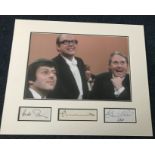 Morecambe and Wise, plus Andre Previn autographs mounted with colour photo in a display.