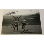 Geoff Hurst signed 12 x 8 inch b/w photo celebrating scoring in 1966 football World Cup Final.