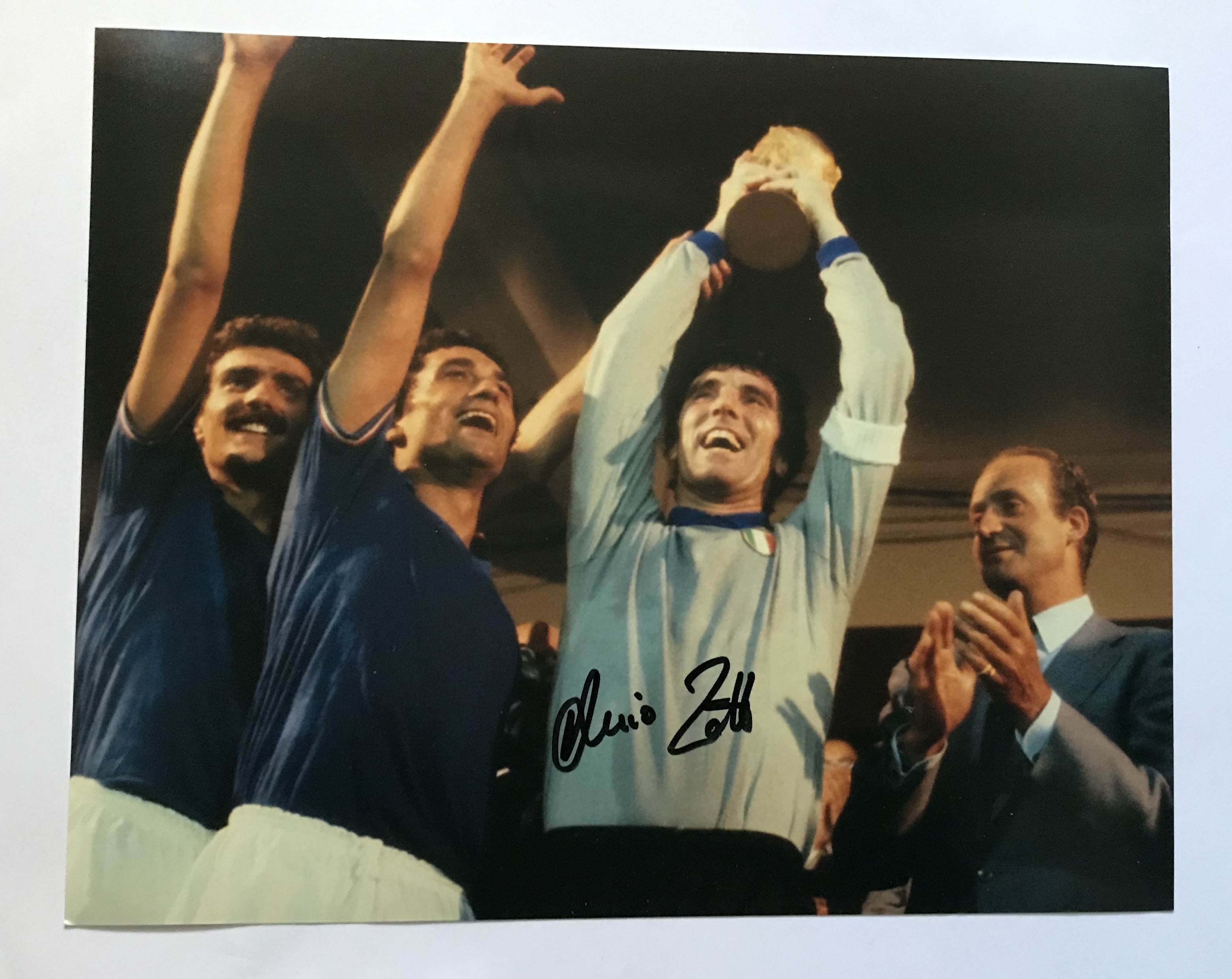 Dino Zoff signed 10 x 8 inch colour photo with World Cup Football trophy held aloft. Good condition.