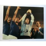 Dino Zoff signed 10 x 8 inch colour photo with World Cup Football trophy held aloft. Good condition.