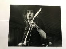 Mick Jones The Clash signed 10 x 8 inch b/w photo on stage playing guitar. Good condition. All