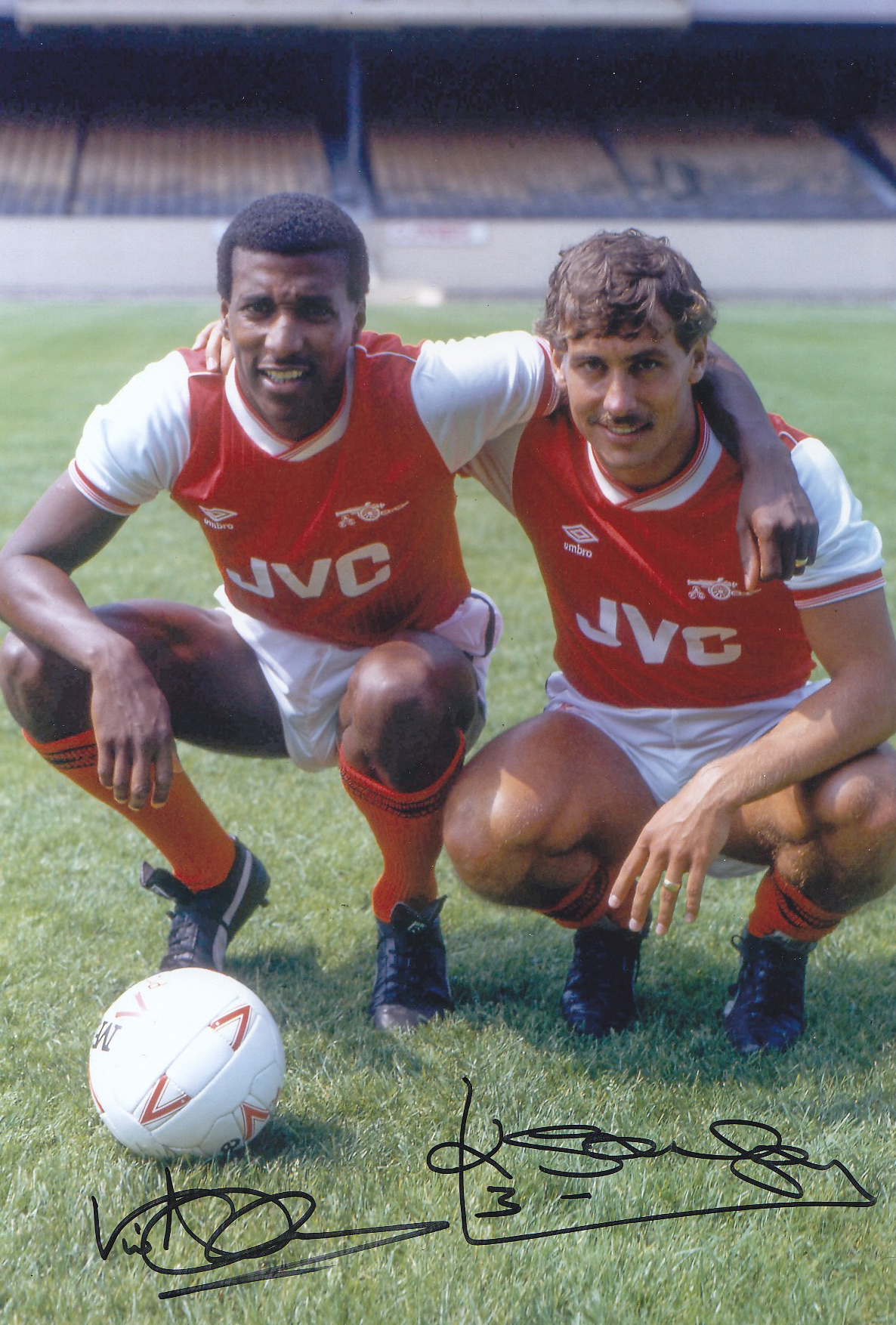 Autographed ARSENAL 12 x 8 photo - Col, depicting Arsenal's VIV ANDERSON and KENNY SANSOM striking a