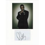 P. Diddy autograph mounted display. Mounted with photograph to approx. 16 x 12 inches overall.