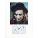 Boy George autograph mounted display. Mounted with photograph to approx. 16 x 12 inches overall.