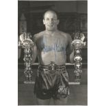 Boxer Henry Cooper signed 6x4 original black and white photo showing Cooper wearing his Lonsdale