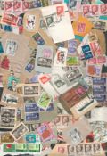 Assortment of world stamps on backing paper. Most quantity of GB stamps. Good condition. We